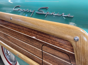 Close-up image of a turquoise, wood and chrome vintage Country Squire car logo