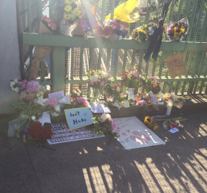 at the Hollywood Max Stop Memorial of flowers and a "don't hate" sign for Rick Best and Taliesin Meche