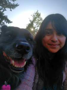 farmer letting dogheart smiles brightly with her dog in front of a setting sun