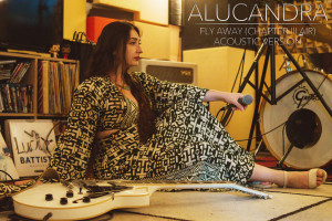 Alucandra laying on stage holding a microphone. Alucandra laying on stage holding a microphone.