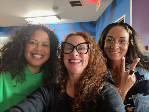 three women smiling in the radio station lobby